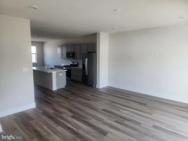 a kitchen with wooden floors and stainless steel appliances