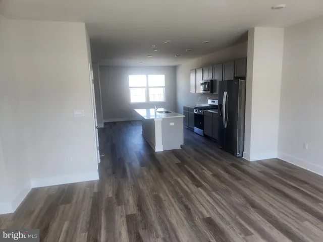 a kitchen with wooden floor and stainless steel appliances