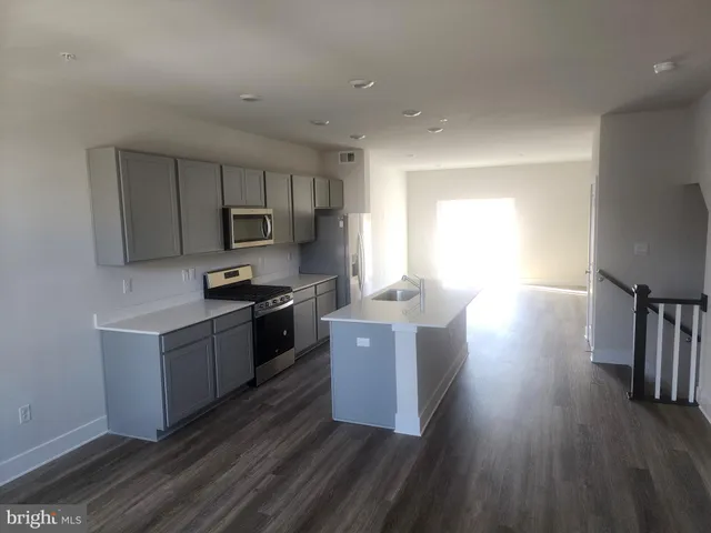 a kitchen with stainless steel appliances granite countertop wooden cabinets a stove top oven a sink and dishwasher