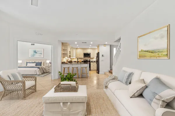 a living room with furniture and a view of kitchen