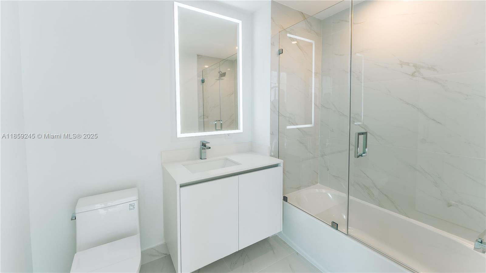 700 Northeast 24th Street, Unit 3401 Miami, FL 33137 - Photo 45 of 68 a bathroom with a granite countertop sink a toilet and shower