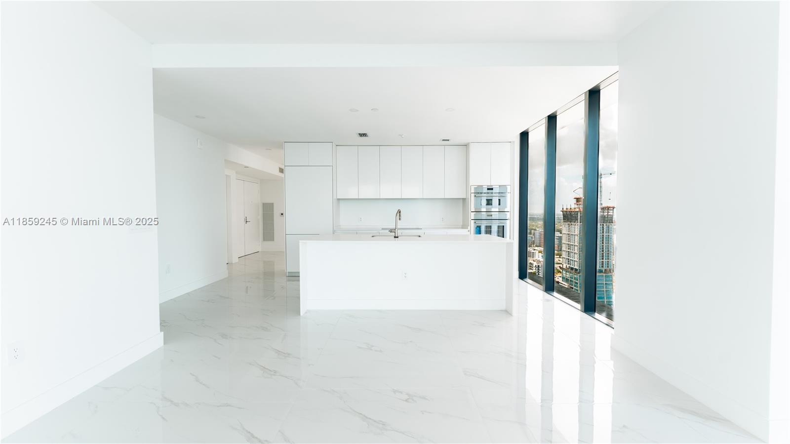 700 Northeast 24th Street, Unit 3401 Miami, FL 33137 - Photo 59 of 68 a large white room with kitchen view and a cabinets