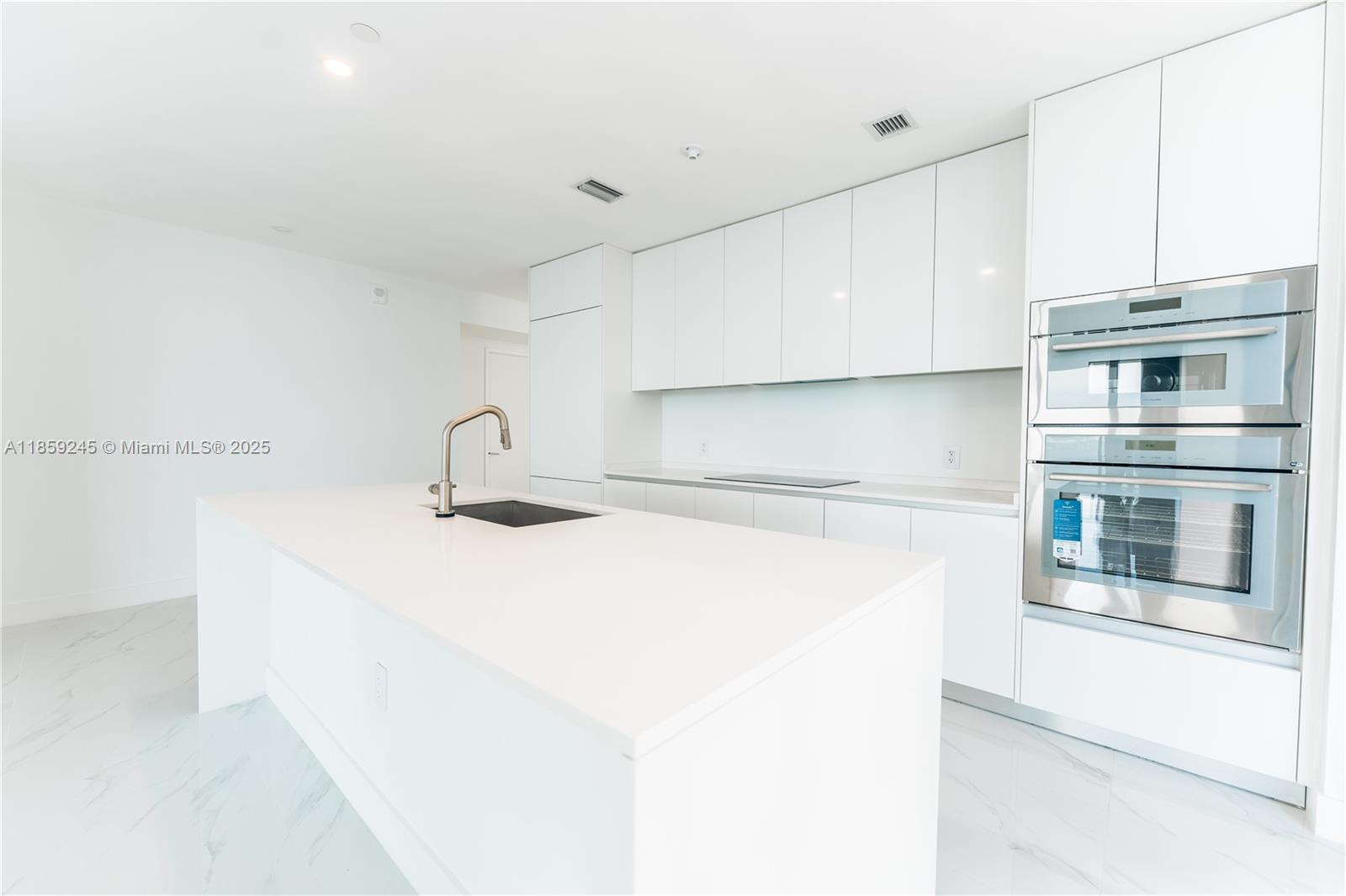 700 Northeast 24th Street, Unit 3401 Miami, FL 33137 - Photo 61 of 68 a kitchen with a sink and a stove top oven
