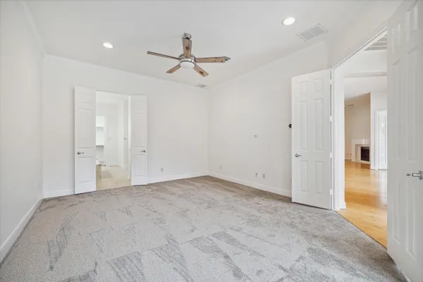 a view of an empty room with a window and a kitchen