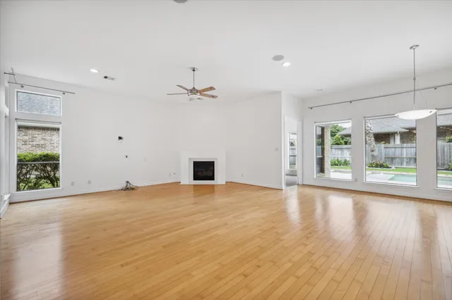a view of an empty room with a window and a kitchen