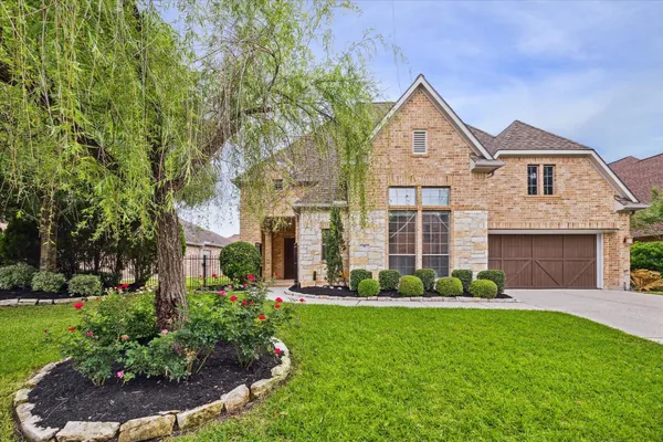 a front view of a house with a garden and plants