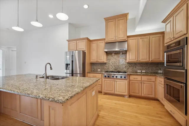 a kitchen with stainless steel appliances granite countertop a sink stove and cabinets