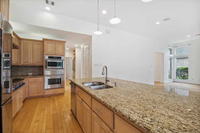 a kitchen with stainless steel appliances granite countertop a sink and cabinets