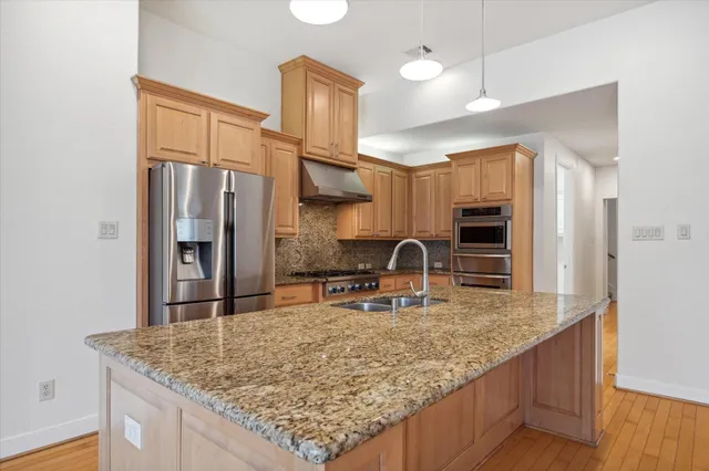 a kitchen with stainless steel appliances granite countertop a sink a oven and refrigerator