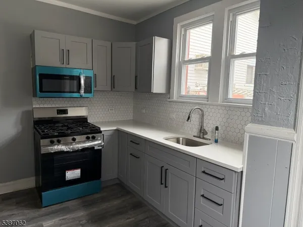 a kitchen with cabinets stainless steel appliances a sink and a window
