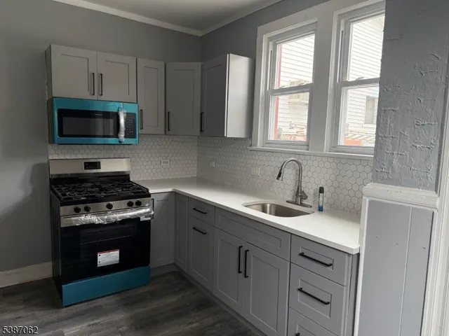 a kitchen with cabinets stainless steel appliances a sink and a window