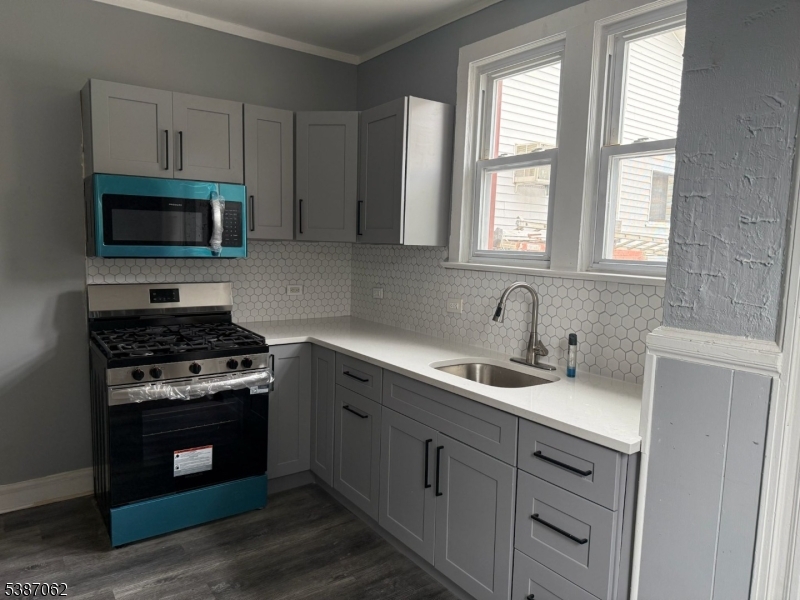 31 Tappan Street, Unit 1 Kearny, NJ 07032 - Photo 2 of 9 a kitchen with cabinets stainless steel appliances a sink and a window