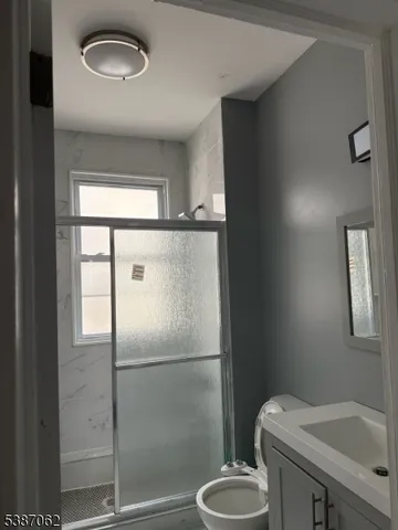 a bathroom with a sink a toilet and a mirror