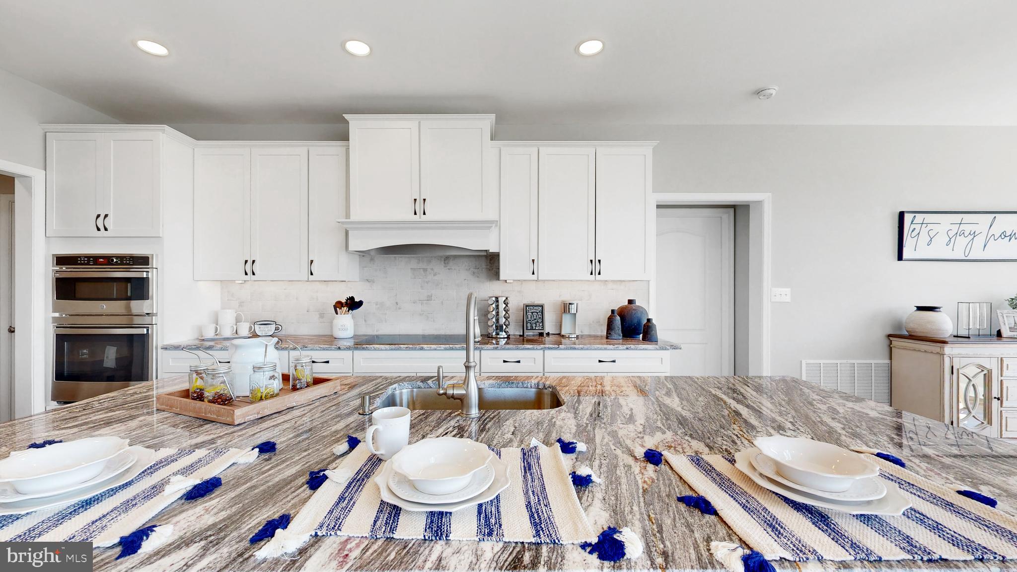 3 Mt Joy Road Millsboro, DE 19966 - Photo 7 of 43 a open kitchen with stainless steel appliances granite countertop a sink a stove a dining table and chairs with wooden floor