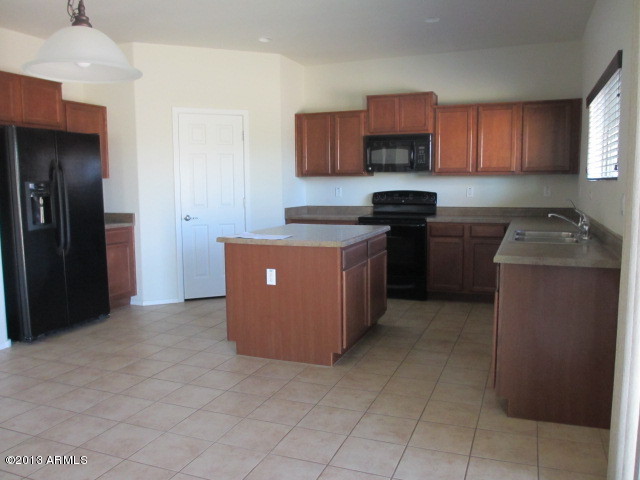 43500 West Magnolia Road Maricopa, AZ 85138 - Photo 5 of 35 a kitchen with stainless steel appliances granite countertop a stove a refrigerator a sink and a oven