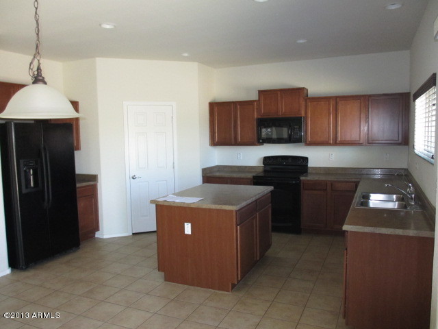 43500 West Magnolia Road Maricopa, AZ 85138 - Photo 6 of 35 a kitchen with a cabinets and a stove