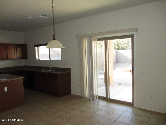 43500 West Magnolia Road Maricopa, AZ 85138 - Photo 7 of 35 a kitchen with a refrigerator and a sink