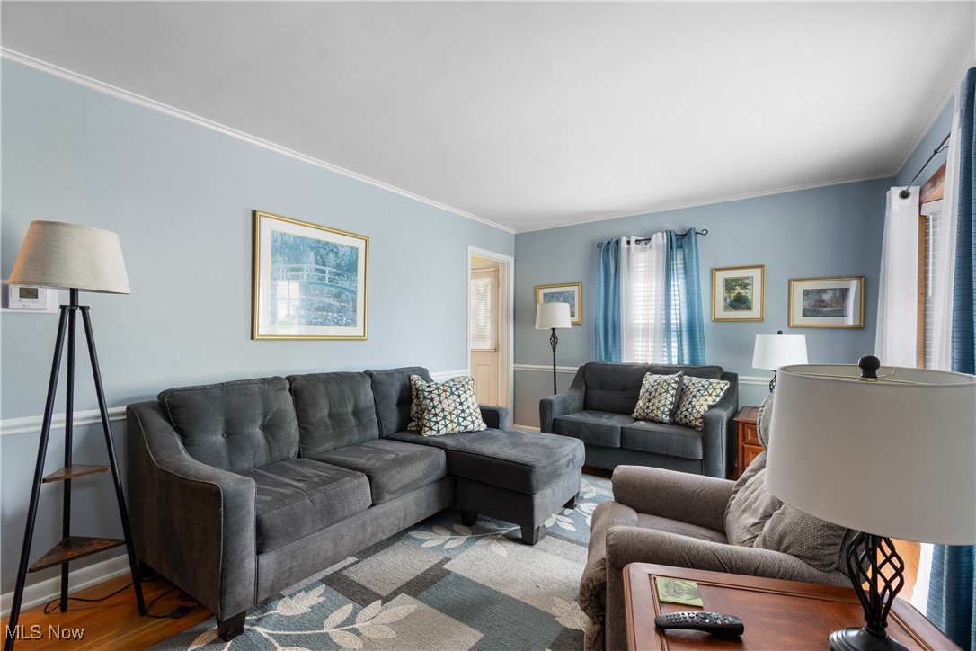 Living area featuring crown molding and wood finished floors