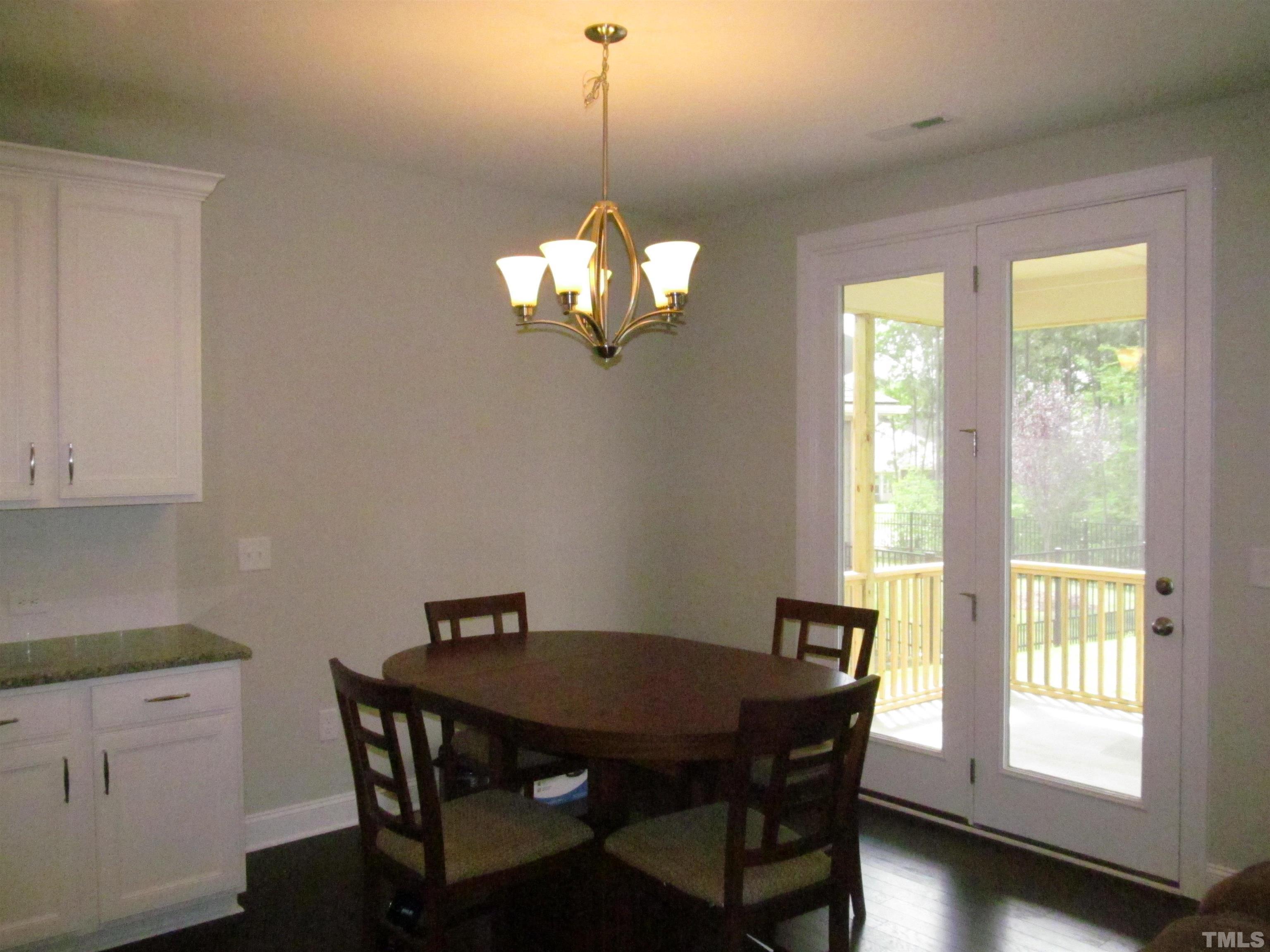 1248 Magic Hollow Road Durham, NC 27713 - Photo 4 of 13 a dining room with wooden floor and a chandelier