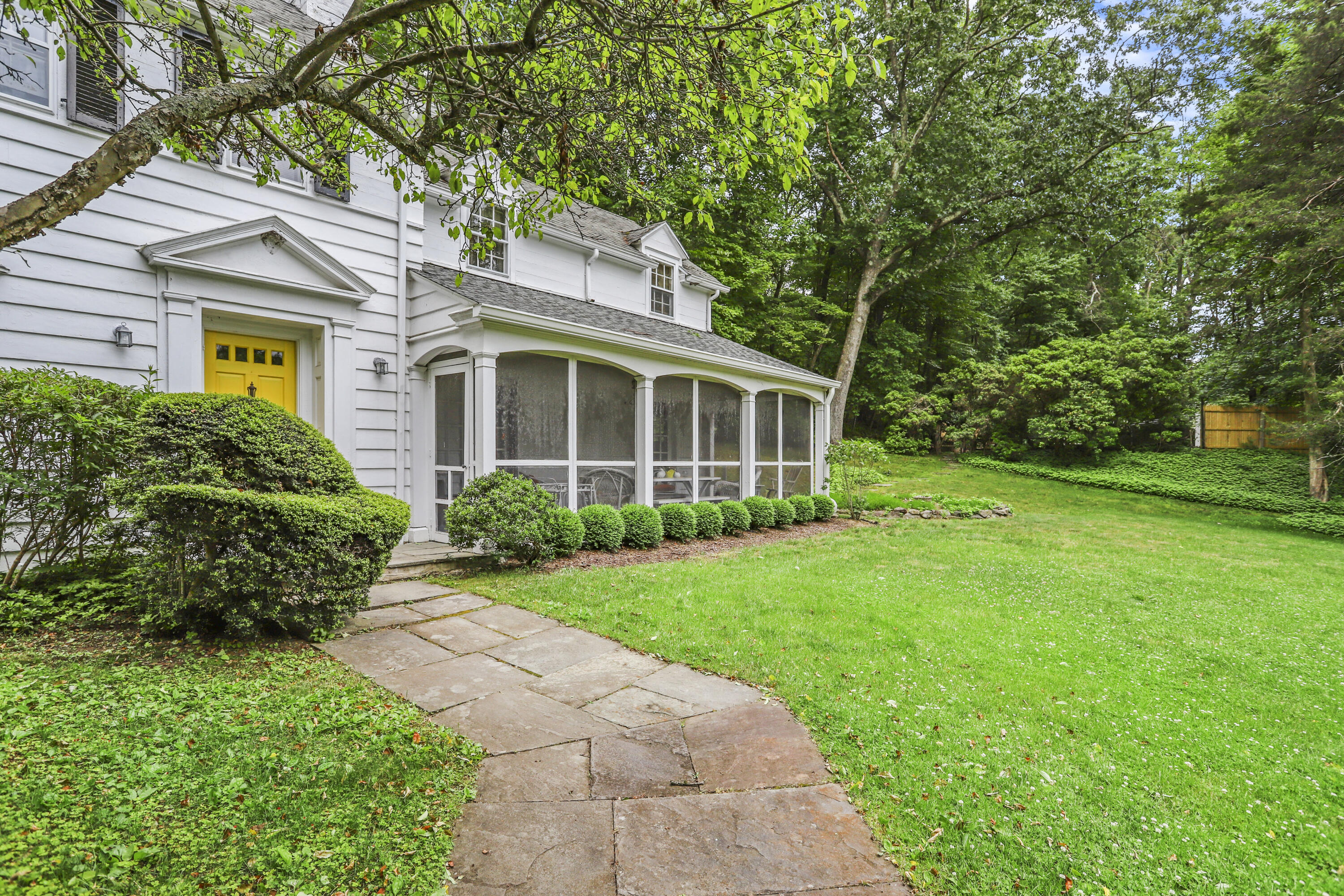 165 Colonial Road New Canaan, CT 06840 - Photo 3 of 37 front view of a house with a yard