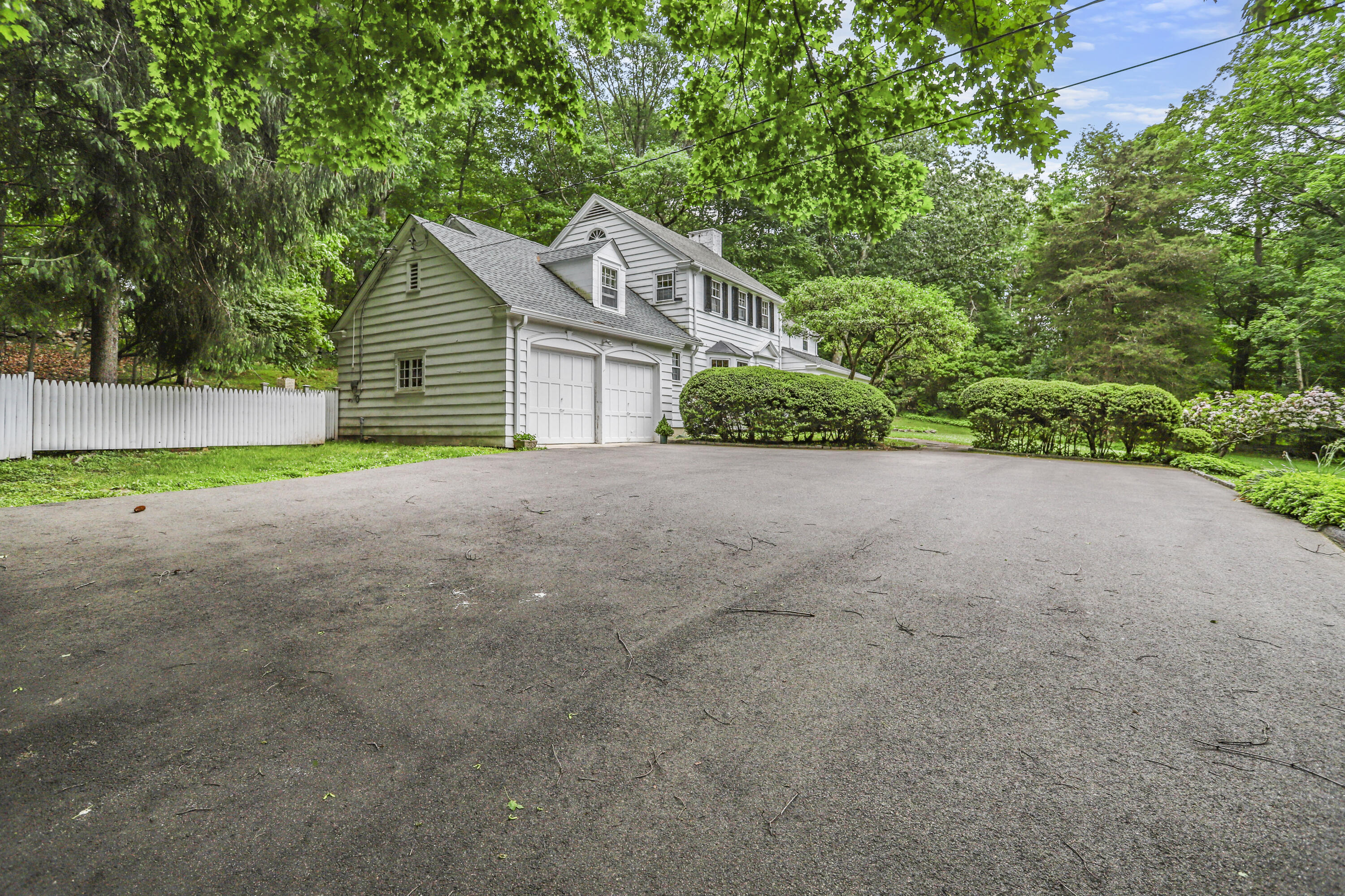 165 Colonial Road New Canaan, CT 06840 - Photo 34 of 37 a view of a house with a yard and large trees