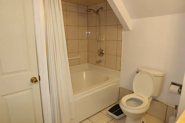 a white toilet sitting next to a bathtub
