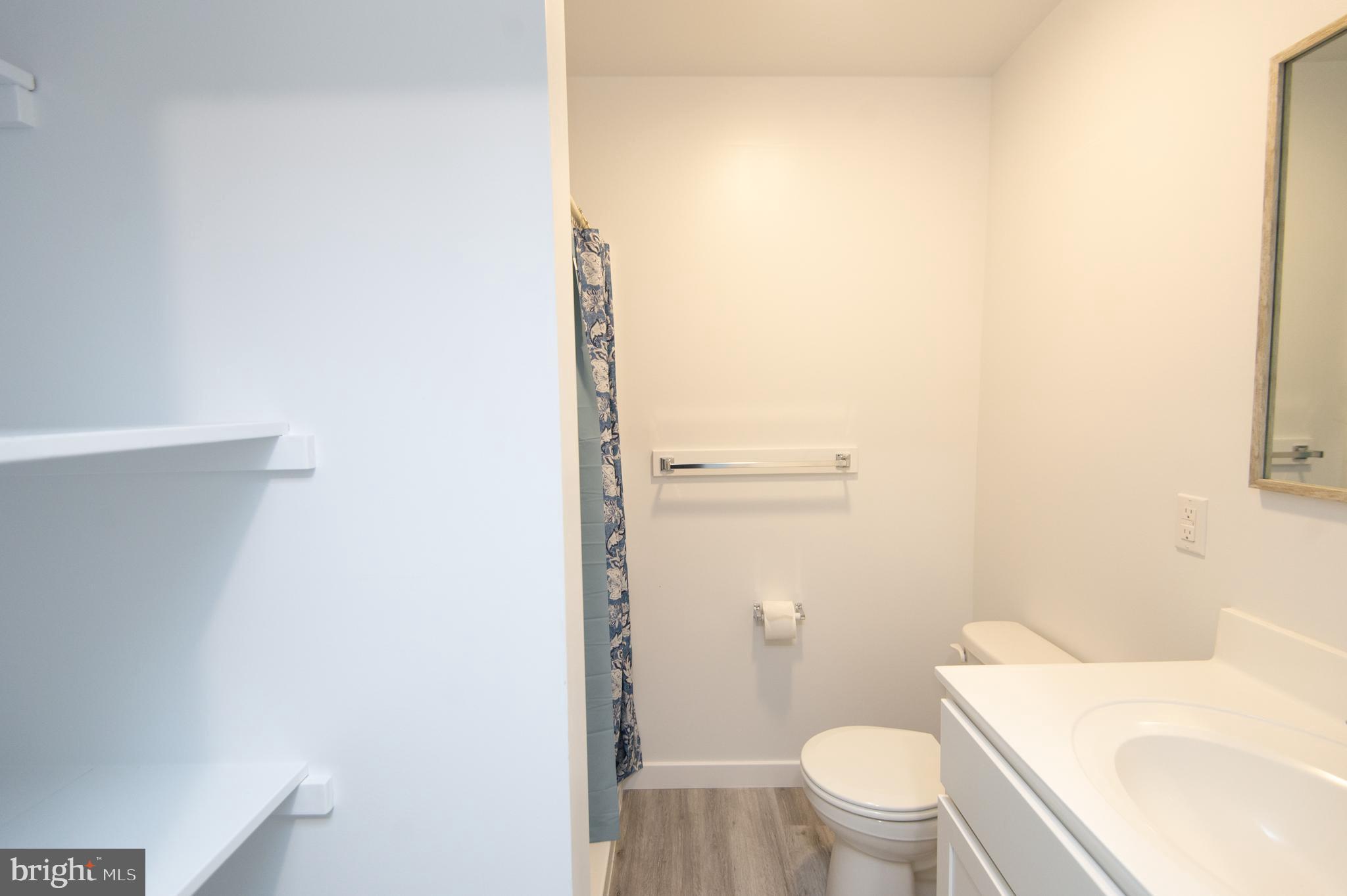 904 Oakley Terrace Cambridge, MD 21613 - Photo 21 of 30 a white toilet sitting next to a white sink and vanity