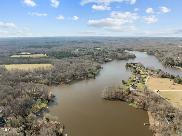 an aerial view of ocean and residential houses with outdoor space