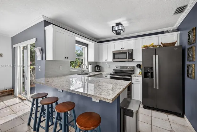 a kitchen with granite countertop a sink stainless steel appliances and cabinets