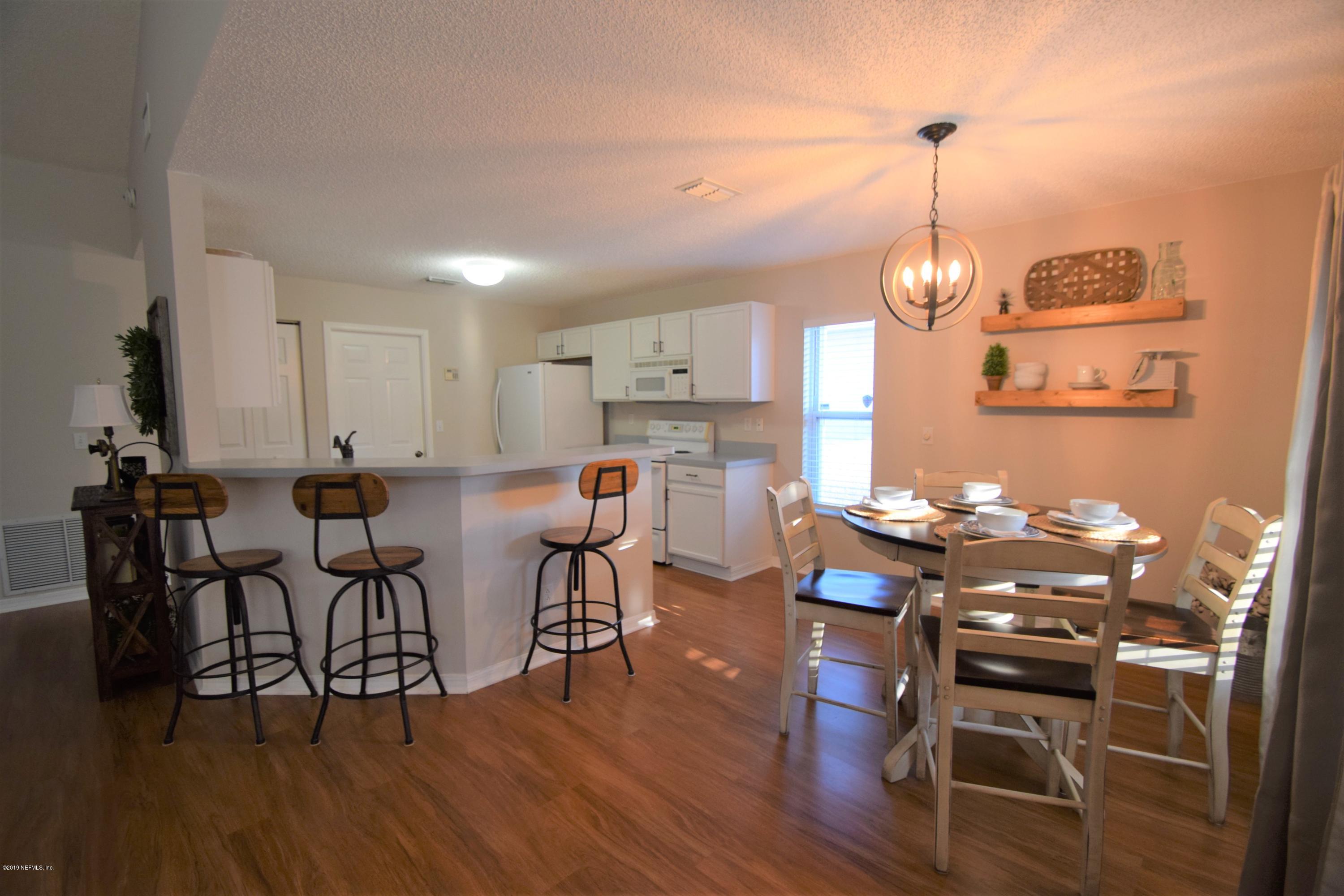 805 Sugarcane Avenue St. Augustine, FL 32095 - Photo 6 of 20 a view of a dining room and livingroom with furniture wooden floor a chandelier