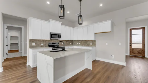 a kitchen with kitchen island white cabinets and stainless steel appliances