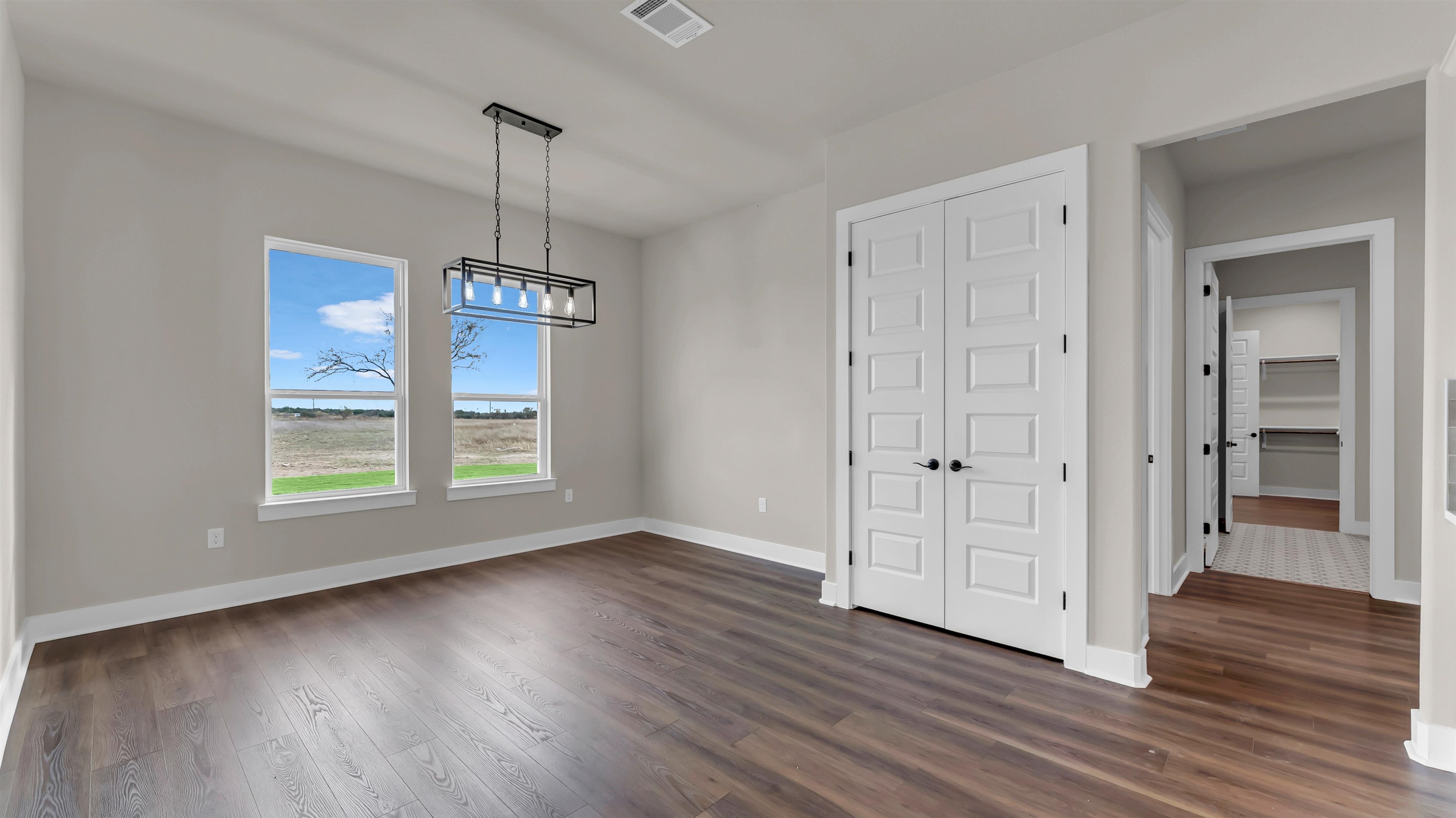379 Prarie Point Road Bertram, TX 78605 - Photo 13 of 30 an empty room with wooden floor cabinet and windows