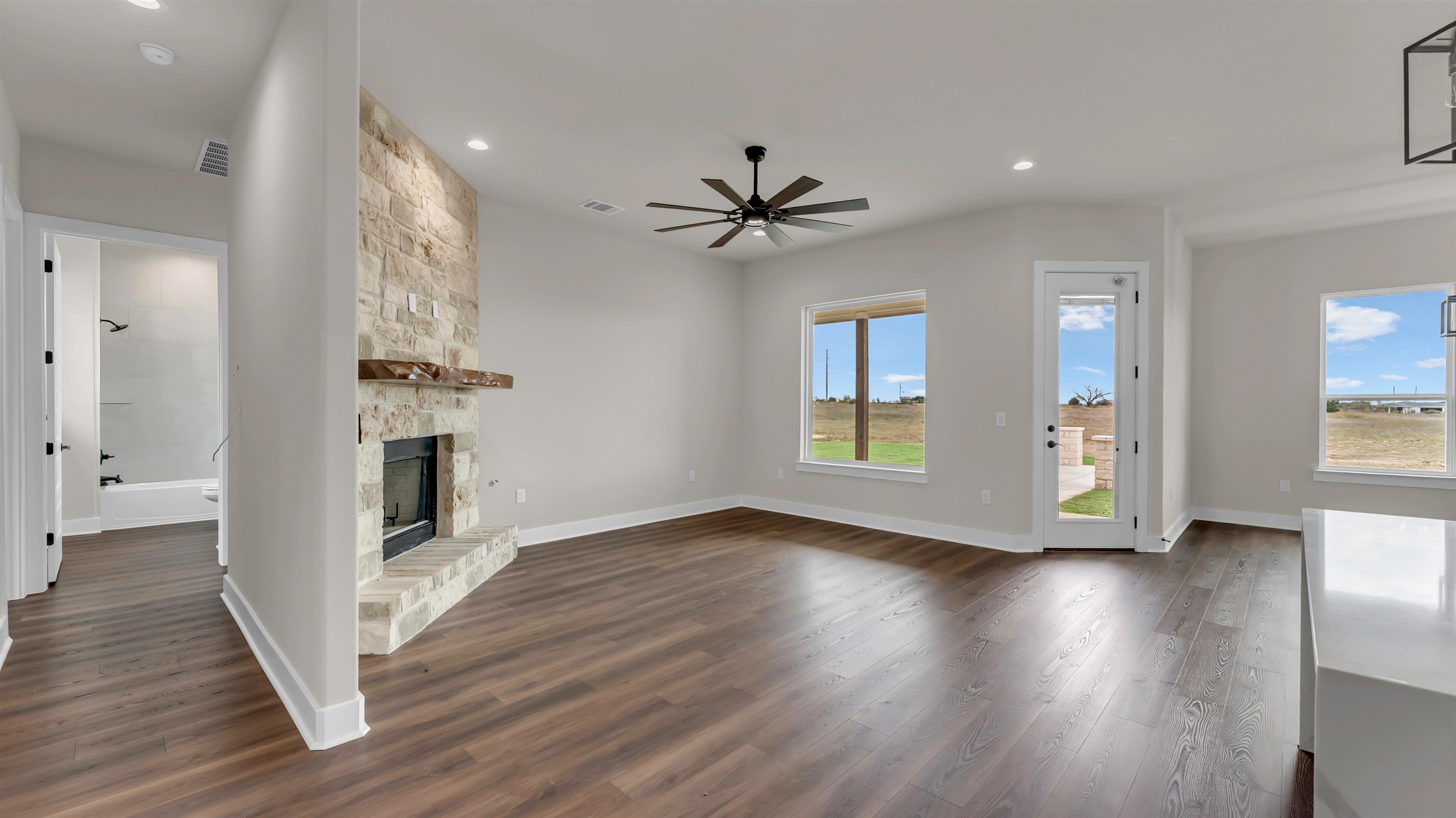 379 Prarie Point Road Bertram, TX 78605 - Photo 5 of 30 a view of an empty room with a window and wooden floor