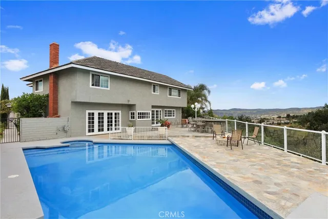 a view of a house with pool and sitting area