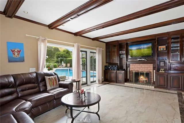 a living room with fireplace furniture and a large window