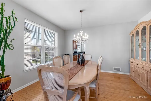 a dining room with furniture a chandelier and wooden floor