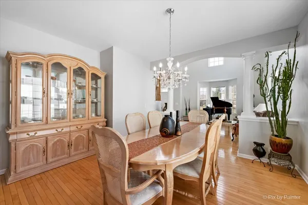 a view of a dining room with furniture a chandelier and wooden floor