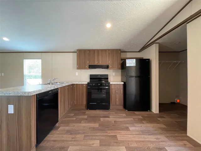 a kitchen with a refrigerator and a stove top oven