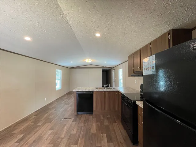 a kitchen with granite countertop a sink and cabinets