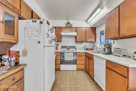 a kitchen with stainless steel appliances granite countertop a refrigerator and a stove top oven