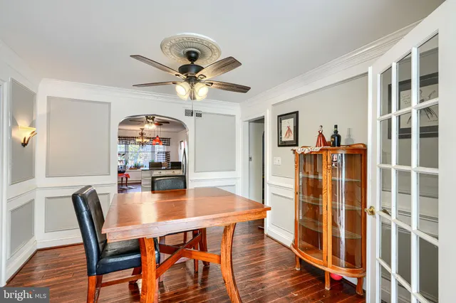 a dining room with furniture a chandelier and wooden floor