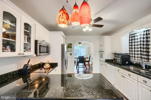 a kitchen with stainless steel appliances granite countertop a stove and cabinets