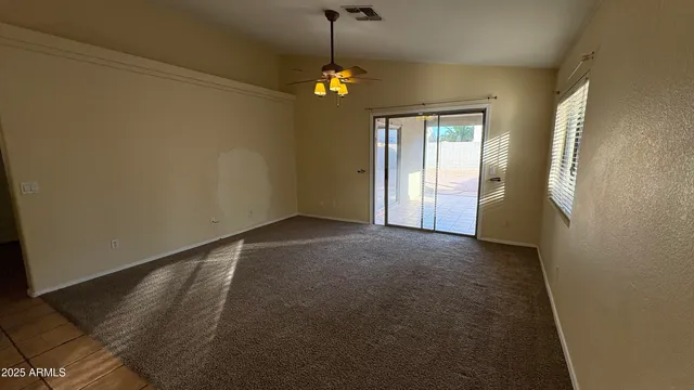 a view of a room with a chandelier fan and windows