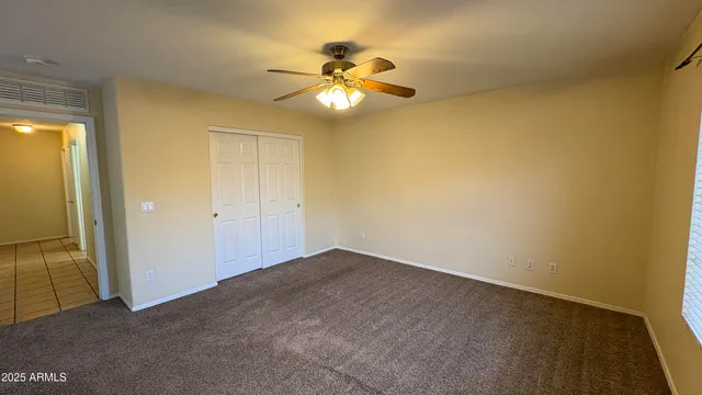 an empty room with a ceiling fan and a bathroom