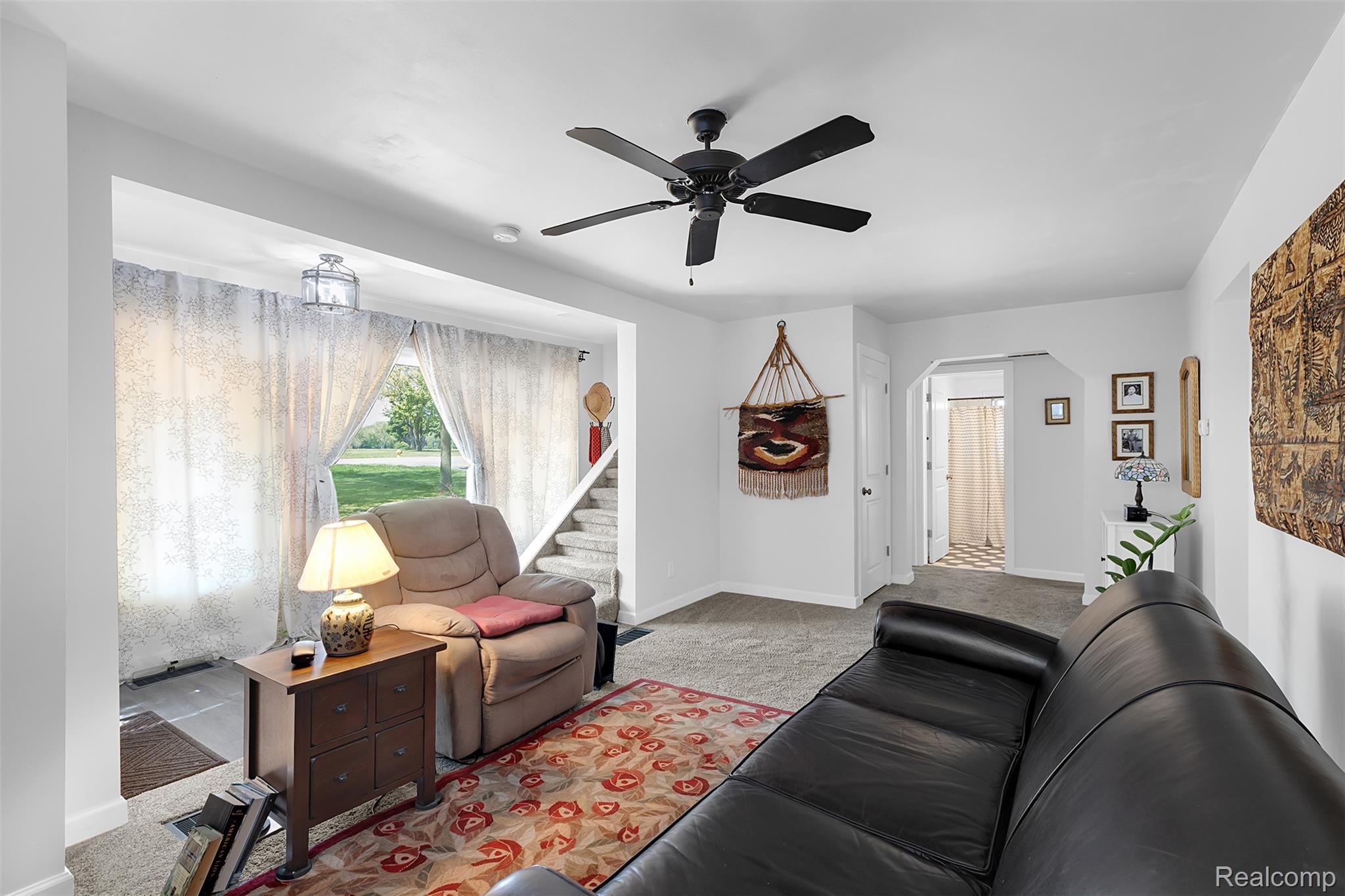 22827 Meridian Road Grosse Ile, MI 48138 - Photo 19 of 36 Carpeted living area featuring a ceiling fan and arched walkways