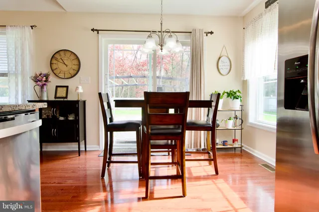 a dining room with wooden floor a glass table and chairs