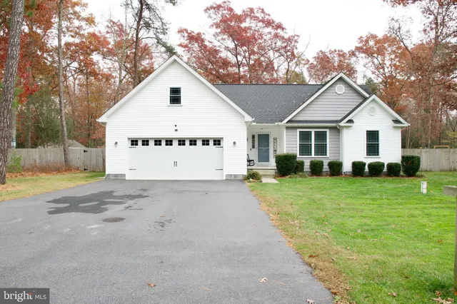 a view of a yard in front of a house with large trees