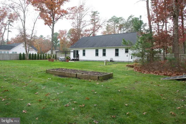 a view of a big house with a big yard and large trees