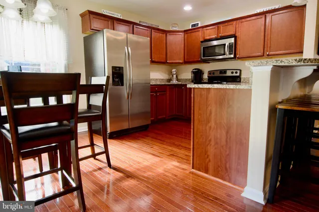 a kitchen with stainless steel appliances granite countertop a refrigerator stove top oven and sink