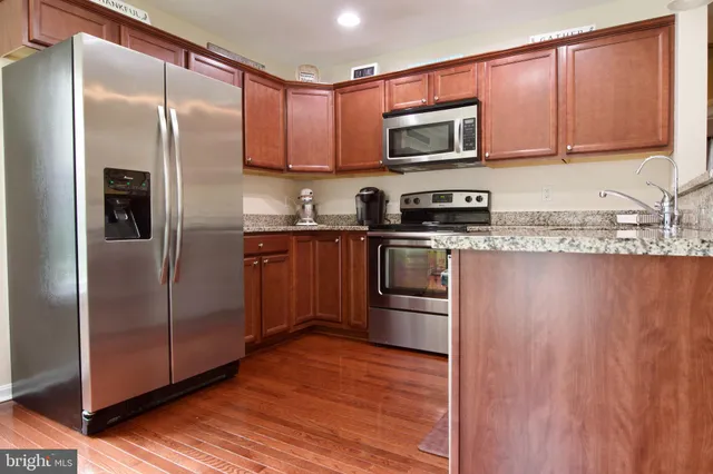 a kitchen with stainless steel appliances granite countertop a refrigerator microwave and sink
